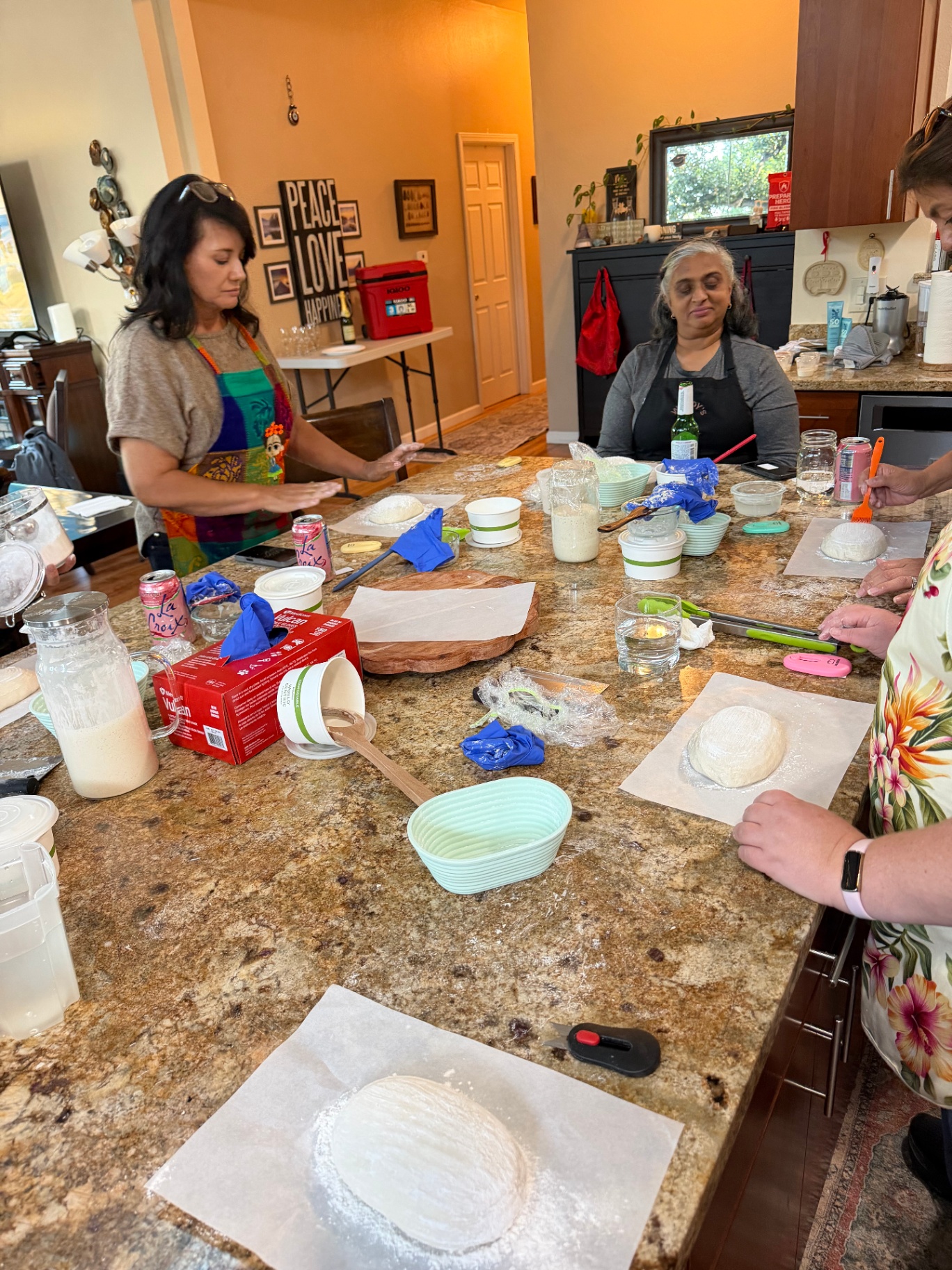 Students shaping dough together around the kitchen island